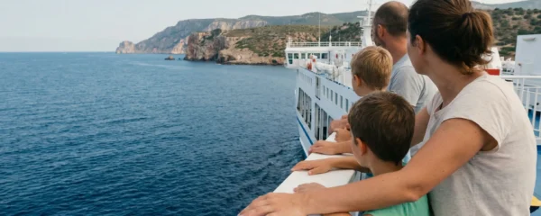 Famille observant la côte sarde depuis le pont d'un ferry en Méditerranée